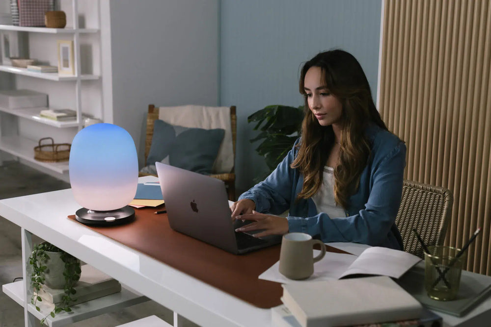 Woman working, skyview lamp on a desk