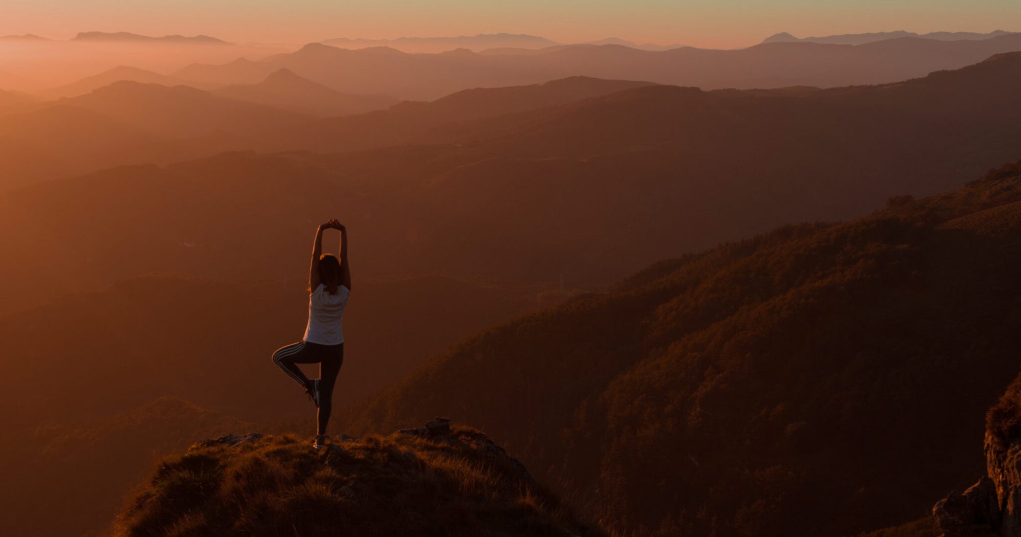 Woman doing yoga on a mountain